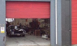 A Roller Shutter shown slightly ajar at a car mechanics garage. 