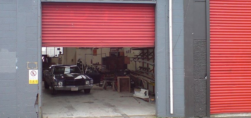 A Roller Shutter shown slightly ajar at a car mechanics garage.